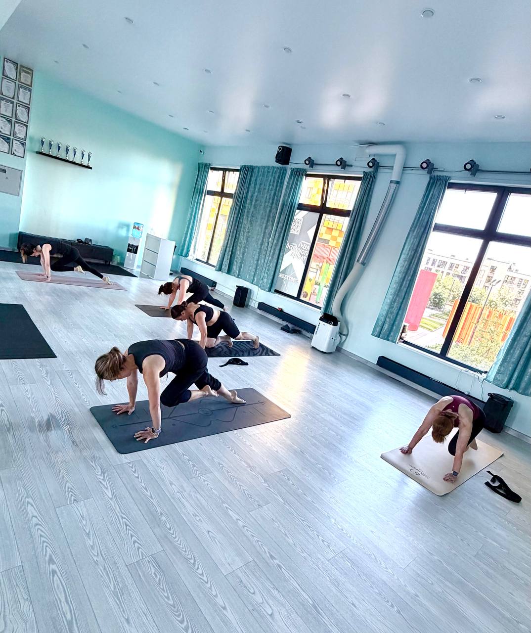 Групповое занятие функциональной йогой в зале YogaCore: упражнение на мобильность позвоночника и силу